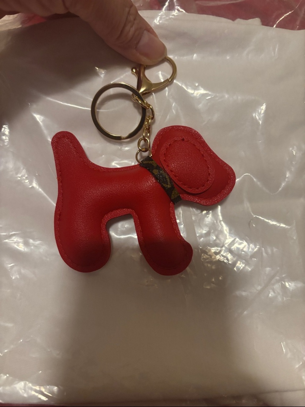 Red dog with gold hardware key chain or bag charm.  Collar made from project bag